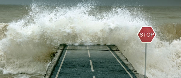 large waves crashing against roadway causing flooding action restoration