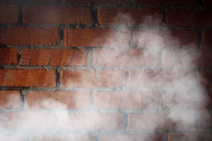 brick wall with white smoke in front of it 